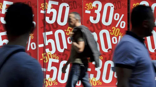 Người dân Brussels (Bỉ) thờ ơ đi qua các cửa hàng giảm giá - Ảnh: Reuters