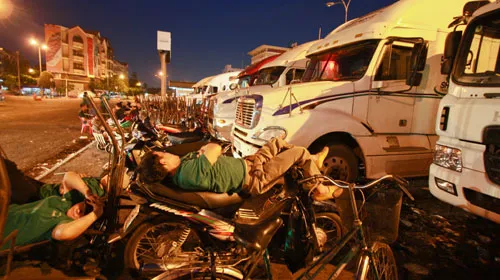 Theo một số cửu vạn tại chợ đầu mối nông sản thực phẩm Thủ Đức, TPHCM, mấy ngày nay xăng tăng giá nên xe vận chuyển hàng hóa về ít chuyến hơn. Trong ảnh: cửu vạn nằm nghỉ, chờ thuê bốc vác hàng từ các xe vận tải