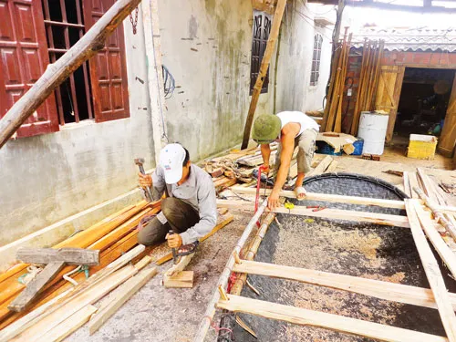 Anh Vũ Văn Thẻ và thợ đang đóng một thuyền nan cỡ nhỏ.