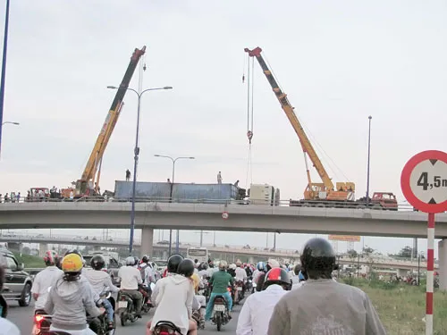 Một vụ lật xe trên cầu vượt Cát Lái khiến hàng trăm người lưu thông bên dưới một phen hú vía. Ảnh: MINH TUẤN