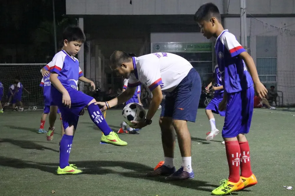 Lưu Ngọc Hùng với các học viên "nhí" trong buổi tập đầu tiên làm quen với bóng. Ảnh: Anh Trần