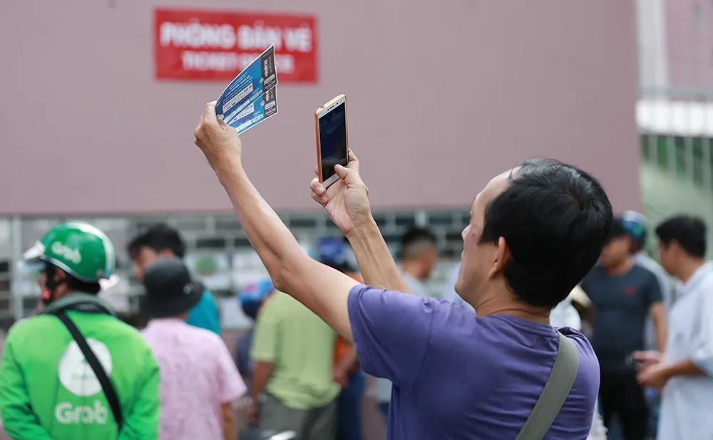 Người hâm mộ kiểm tra xem vé mua liệu có bị làm giả. Ảnh: DŨNG PHƯƠNG