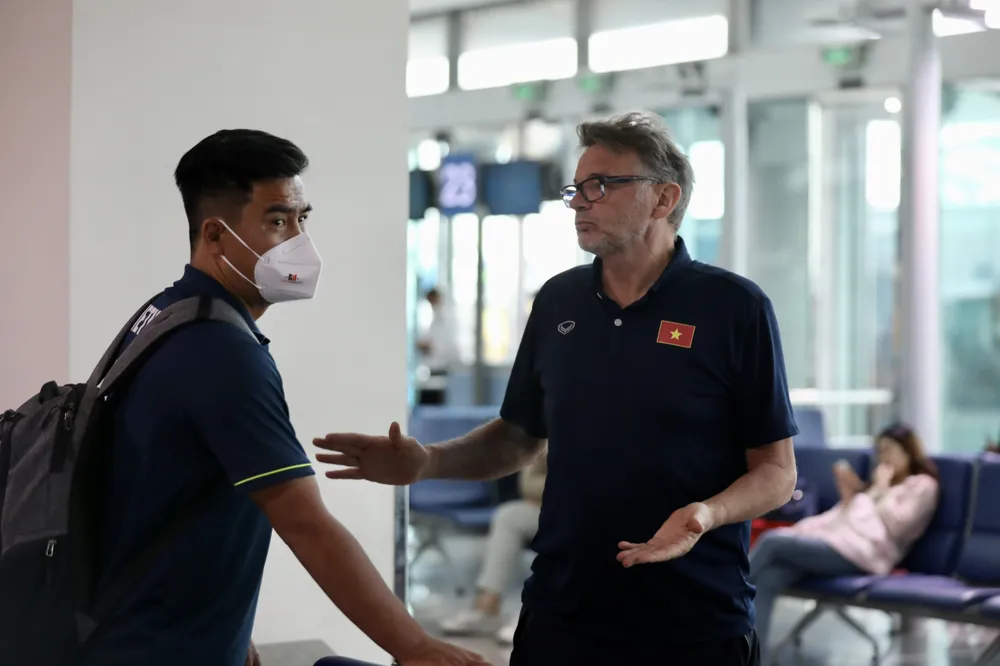 HLV Troussier trao đổi cùng trợ lý Nguyễn Việt Thắng trong khi chờ làm thủ tục