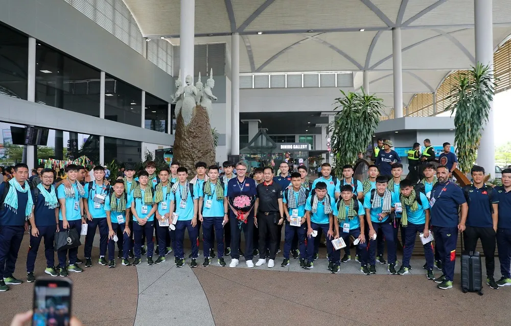 Thầy trò HLV Troussier chụp ảnh lưu niệm khi vừa đến sân bay Phnom Penh. Ảnh: QUỲNH MAI