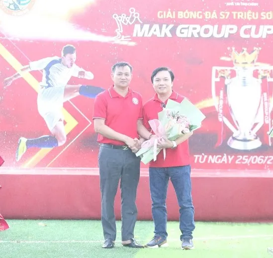 Trưởng ban tổ chức giải Lê Đình Chung (trái) tặng hoa cho ông Lã Văn Tiến đại diện nhà tài trợ chính Mak Group
