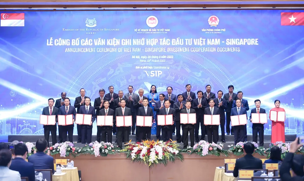 Công bố các văn kiện ghi nhớ hợp tác đầu tư Việt Nam – Singapore với sự chứng kiến của Thủ tướng Nước CHXNCN Việt Nam Phạm Minh Chính (hàng giữa thứ 5 bên phải qua); Thủ tướng Nước Cộng hòa Singapore Lý Hiển Long (hàng giữa thứ 5 bên trái qua)