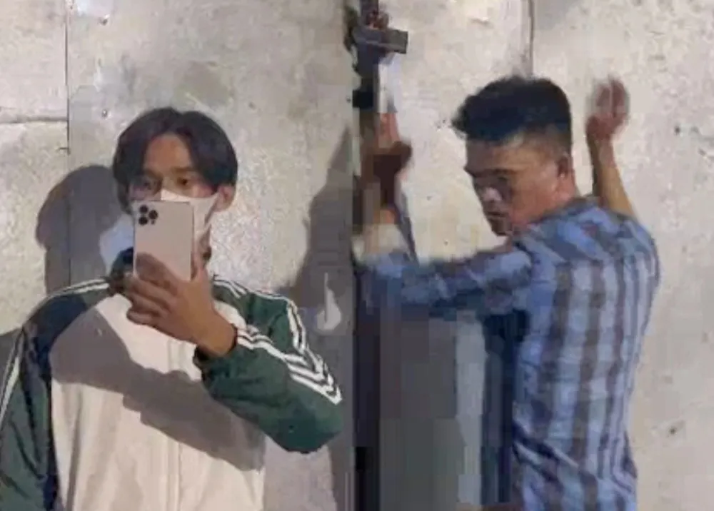 Ông Đào Chí Tâm (phải) khóa cửa nhốt 2 cán bộ của đoàn kiểm tra bên trong công trình