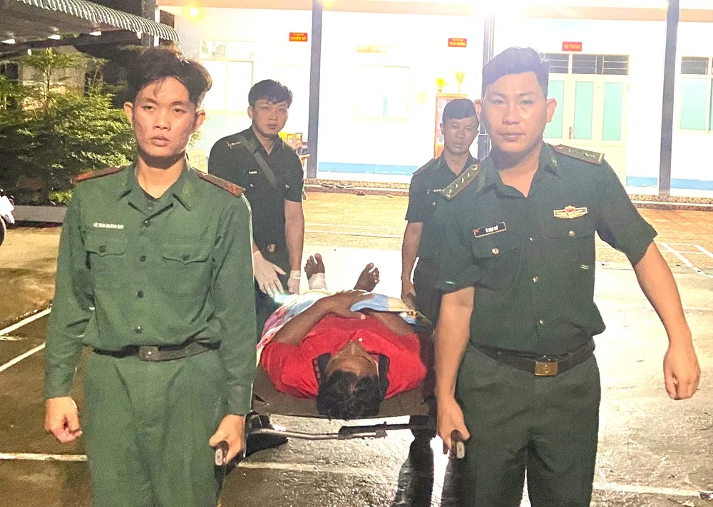 Sơ cứu cho thuyền viên bị thương ở chân. Ảnh: Đồn Biên phòng Khánh Hội cung cấp