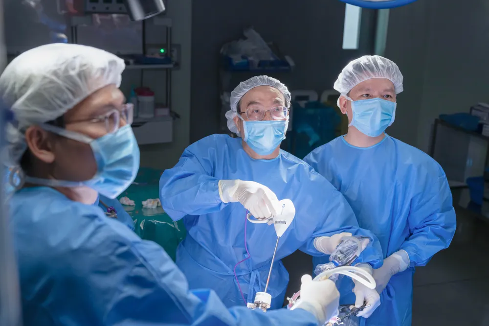 PGS.TS.BS Phạm Đức Huấn (ở giữa) cùng ê-kíp tiến hành phẫu thuật cho bệnh nhân.