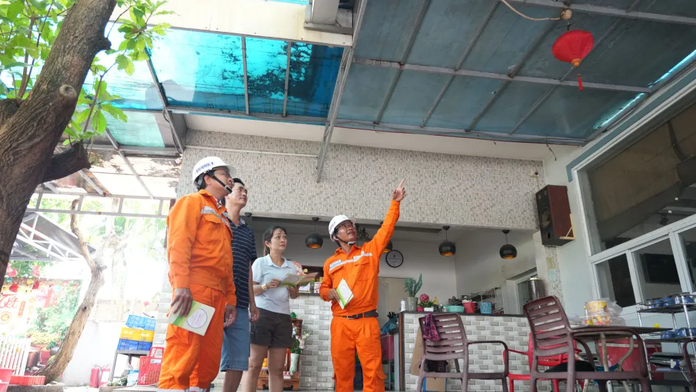 Nhân viên viên ngành điện TPHCM tuyên truyền an toàn điện mùa mưa bão kết hợp khảo sát, tư vấn cho khách hàng (ẢNH: VIỆT HOA)