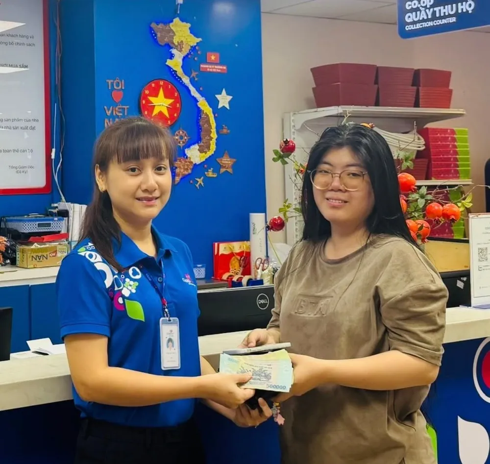 Nhân viên siêu thị trao trả đồ rơi cho khách hàng khi tới mua sắm (ẢNH: HOÀNG AN)