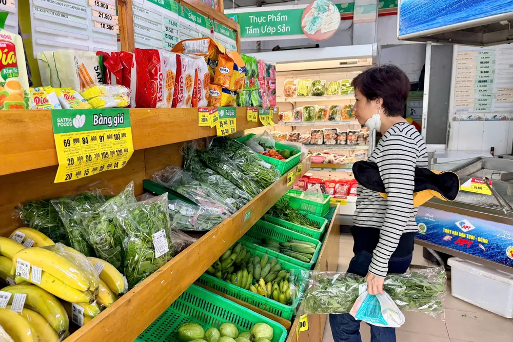 Người tiêu dùng lựa chọn thực phẩm tại cửa hàng Satrafoods đường Lê Thị Riêng, phường Bến Thành, TPHCM (ẢNH: HOÀNG HÙNG)