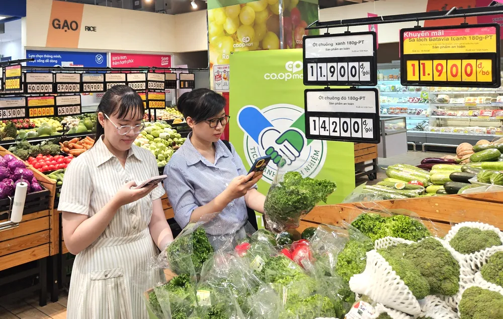 Khách hàng kiểm tra thông tin sản phẩm "Tick xanh trách nhiệm" tại một siêu thị Co.opmart, TPHCM (ẢNH: PHƯƠNG NHI)