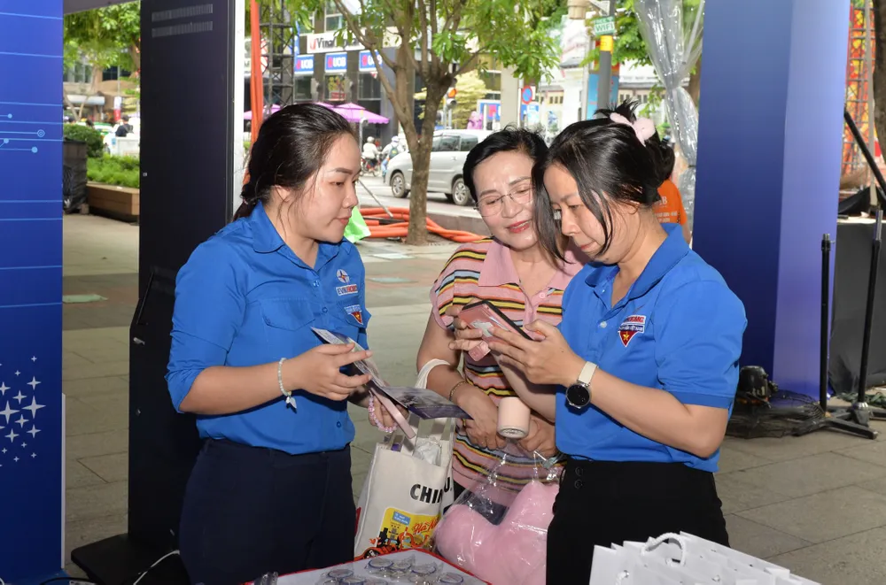 Nhân viên chăm sóc khách hàng của EVNHCMC hướng dẫn người dân cài đặt app