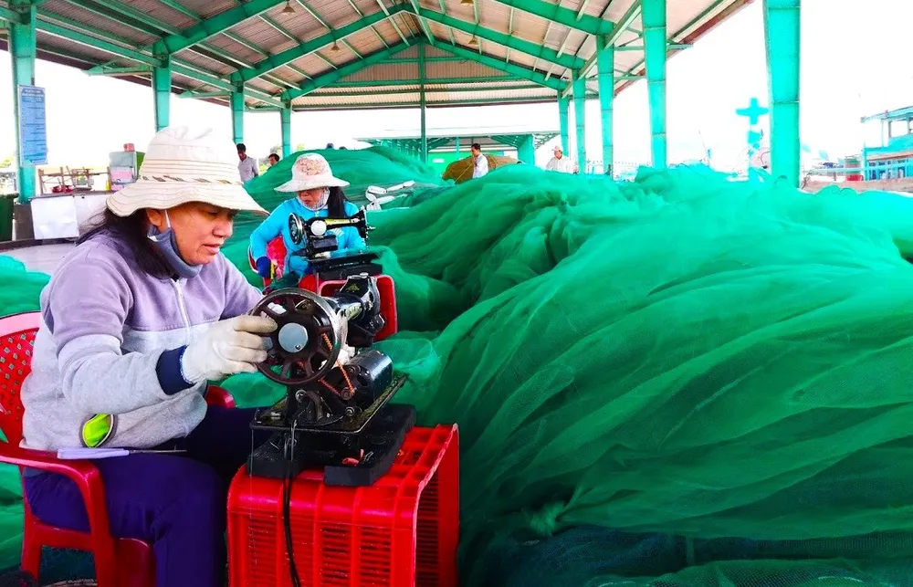 Phụ nữ làng biển ở tỉnh Lâm Đồng cặm cụi vá từng tấm lưới rách