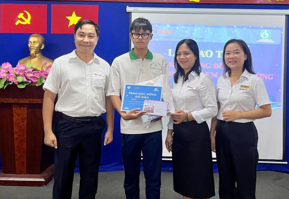 Ông Nguyễn Thanh Nhã, Phó Tổng giám đốc EVNHCMC và đại diện Công đoàn EVNHCMC trao học bổng đỡ đầu cho học sinh tại buổi lễ