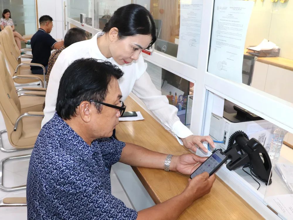 Nhân viên Công ty CP Cấp nước Nhà Bè hướng dẫn người dân thực hiện các giao dịch trên môi trường số