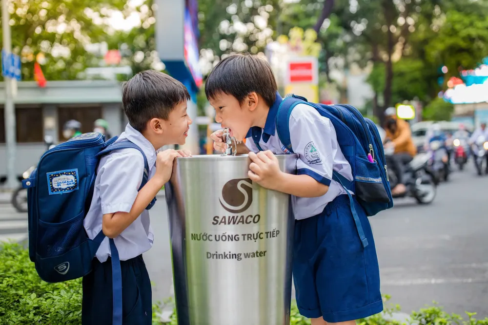 Học sinh thích thú uống nước tại vòi ở TPHCM