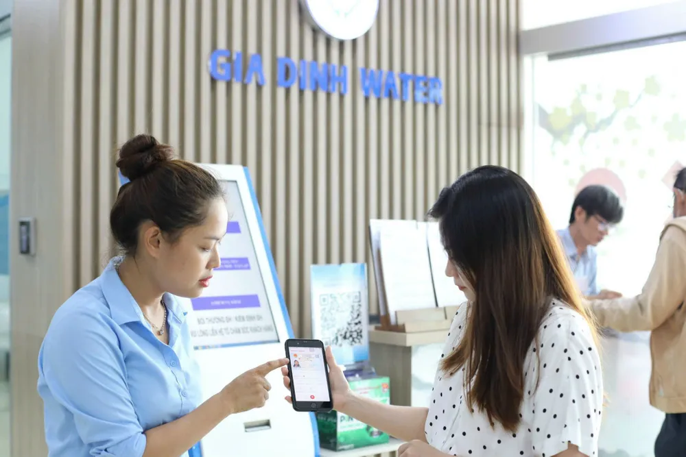 Nhân viên Công ty CP Cấp nước Gia Định hướng dẫn khách hàng thực hiện các giao dịch cấp nước trên môi trường số