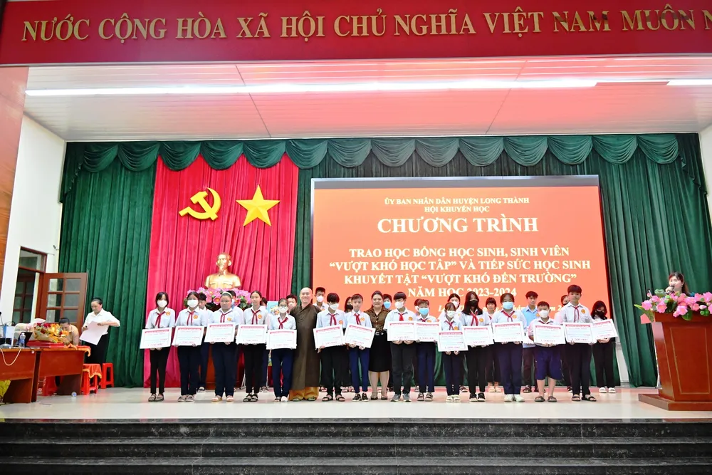 Bà Nguyễn Thu Thủy - Phó Giám đốc đối ngoại Vedan Việt Nam (đứng giữa) trao học bổng cho các em học sinh