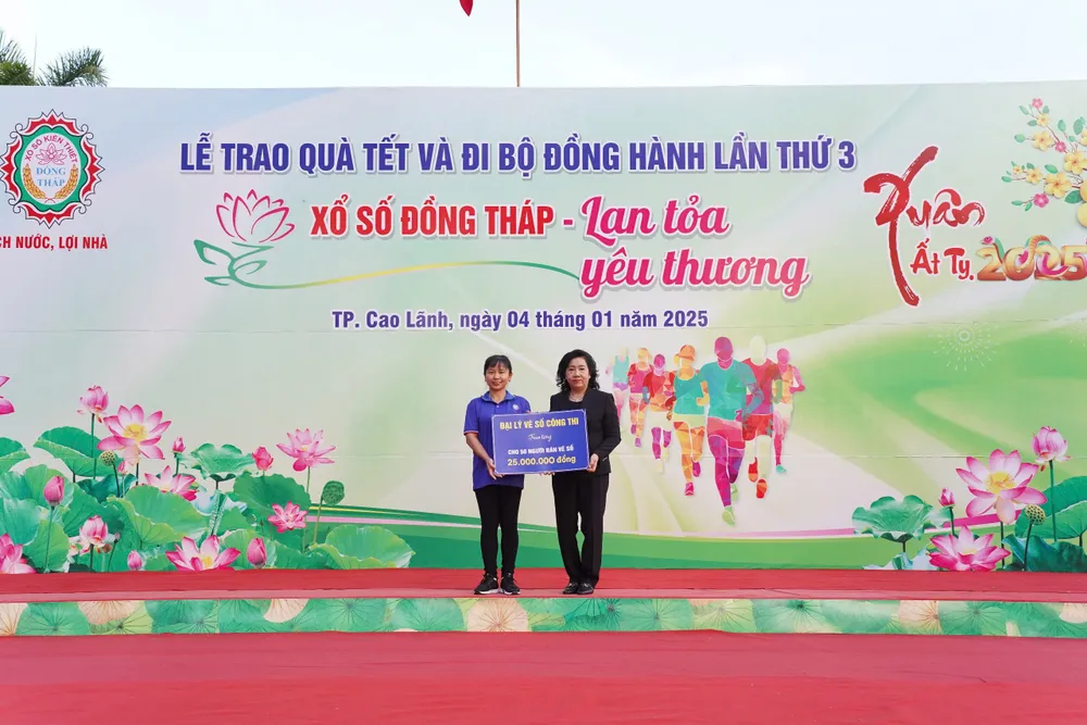 Bà Đặng Thị Ngọc Hiền-Giám đốc Công ty XSKT Đồng Tháp nhận bảng tài trợ từ Đại lý vé số Nguyễn Công Thi tài trợ cho người bán vé số dạo trong Tỉnh.JPG