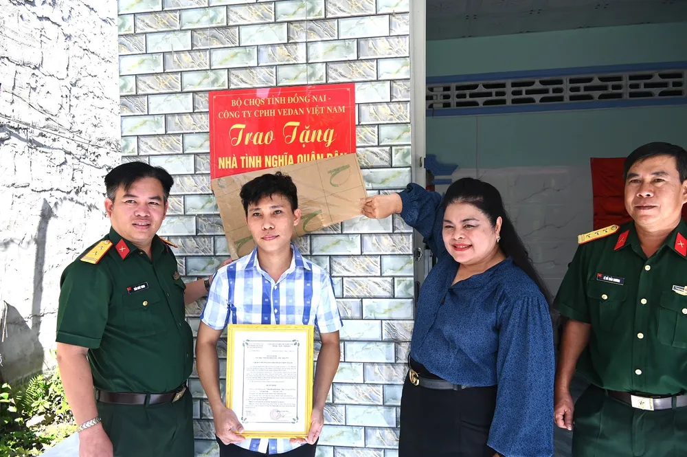 Đồng chí Trần Nhất Trung - Chỉ huy trưởng BCHQS huyện Nhơn Trạch và Bà Nguyễn Thu Thủy Phó giám đốc đối ngoại Vedan bàn giao nhà cho gia đình anh Võ Văn Lâm.JPG