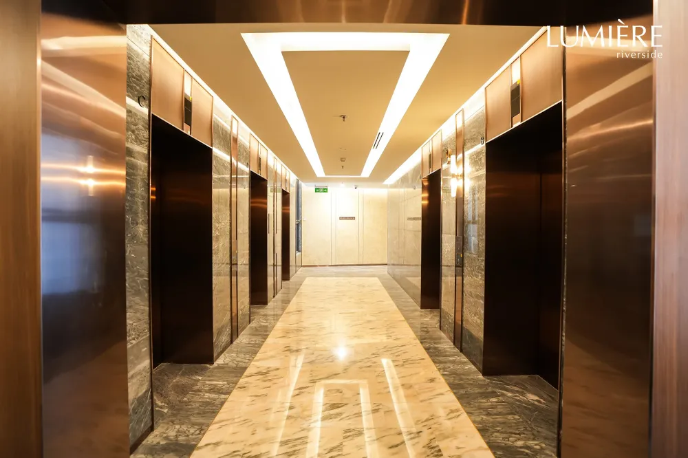 Cổng vào (trái) và sảnh thang máy tiêu chuẩn khách sạn 5 sao của LUMIÈRE riverside - dự án đầu tiên trong BST LUMIÈRE chuẩn bị bàn giao trong 2023