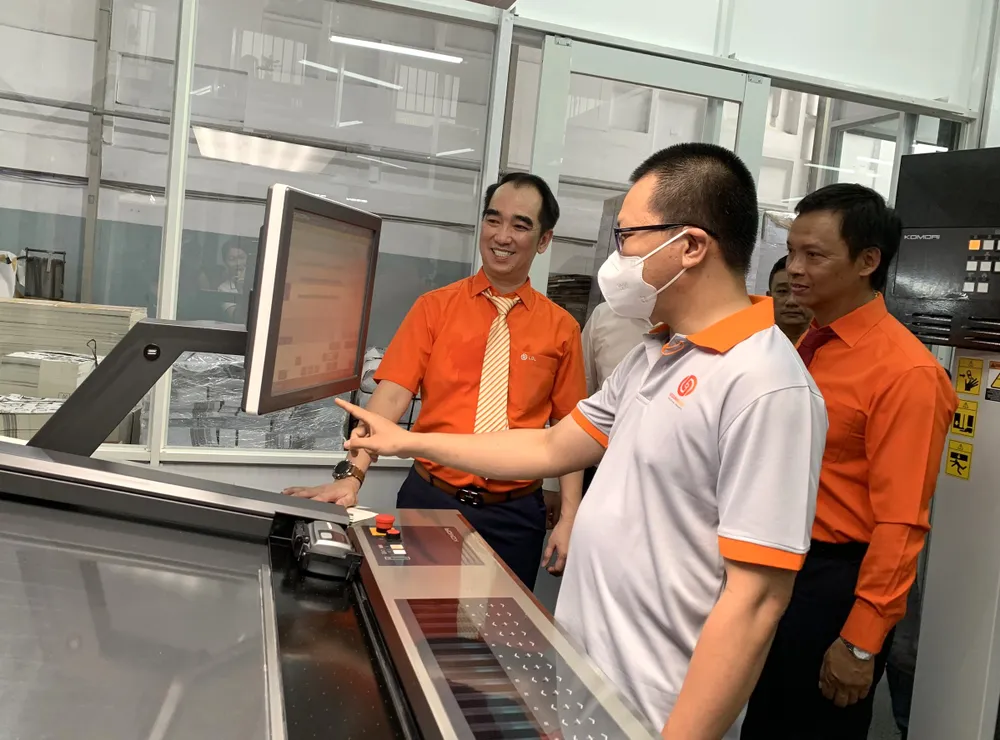 Giám đốc Công ty TNHH MTV Lê Quang Lộc Nguyễn Tri Quang (trái) cùng tham gia vận hành hệ thống máy in mới trong ngày 13-5.jpg