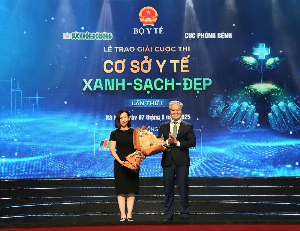 Nhà báo Trần Tuấn Linh, Tổng Biên tập Báo Sức khỏe và Đời sống tặng hoa bà Nguyễn Bạch Điệp, Chủ tịch FPT Retail kiêm Tổng Giám đốc Hệ thống nhà thuốc và tiêm chủng Long Châu - đại diện Nhà tài trợ cuộc thi