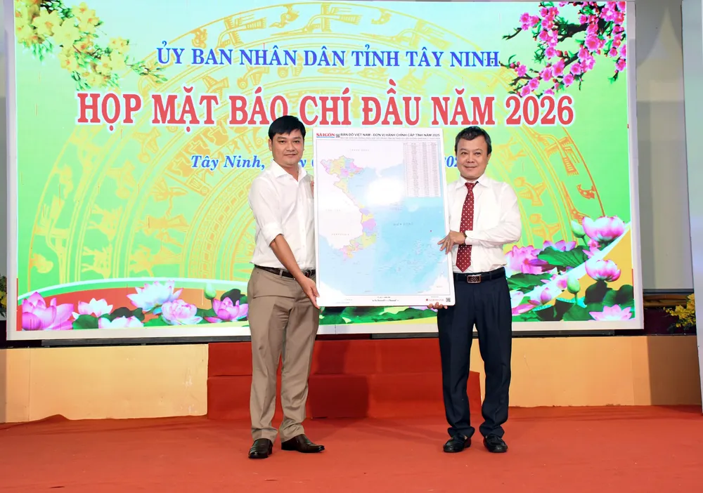 Nhà báo Phạm Minh Tuấn Vũ, Phó trưởng Phụ trách Văn phòng đại diện Báo Sài Gòn Giải Phóng khu vực ĐBSCL (trái) trao bản đồ Việt Nam tặng đại diện tỉnh Tây Ninh. Ảnh: Quang Vinh