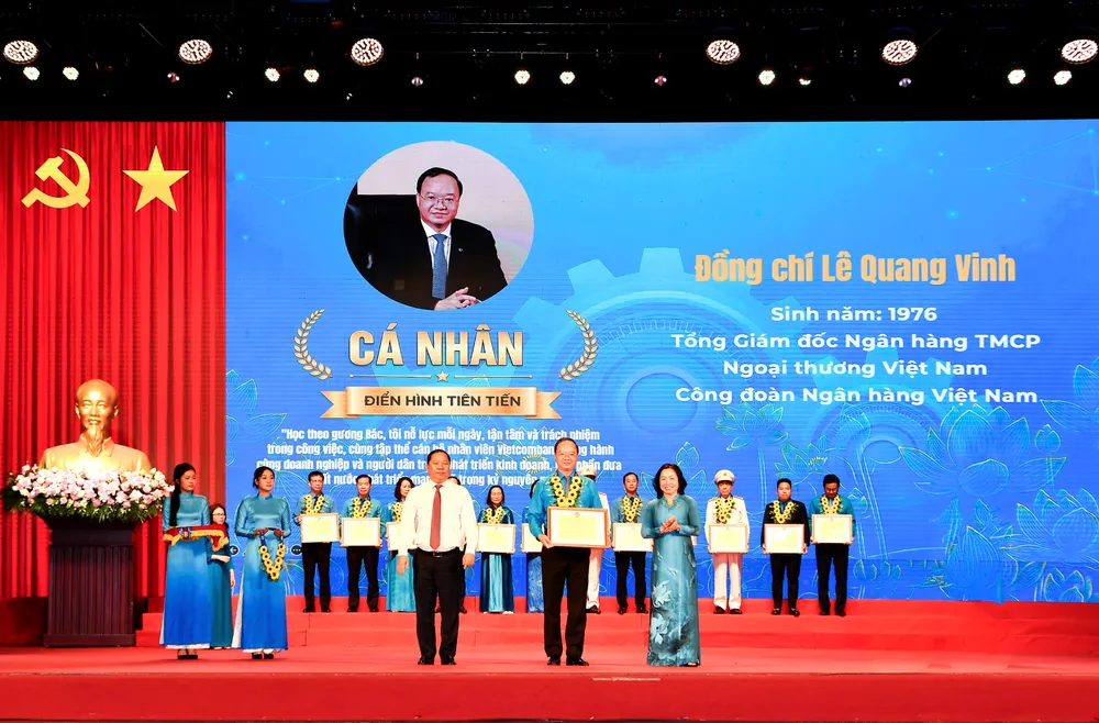 Ông Nguyễn Phi Long, Ủy viên Ban chấp hành Trung ương Đảng, Phó Bí thư Thường trực Đảng ủy Mặt trận Tổ quốc các đoàn thể Trung ương, Phó Chủ tịch Ủy ban Trung ương Mặt trận Tổ quốc Việt Nam (bên trái) trao hoa chúc mừng và Bà Thái Thu Sương - Phó Chủ tịch thường trực Tổng Liên đoàn Lao động Việt Nam (bên phải) trao bằng khen cho ông Lê Quang Vinh