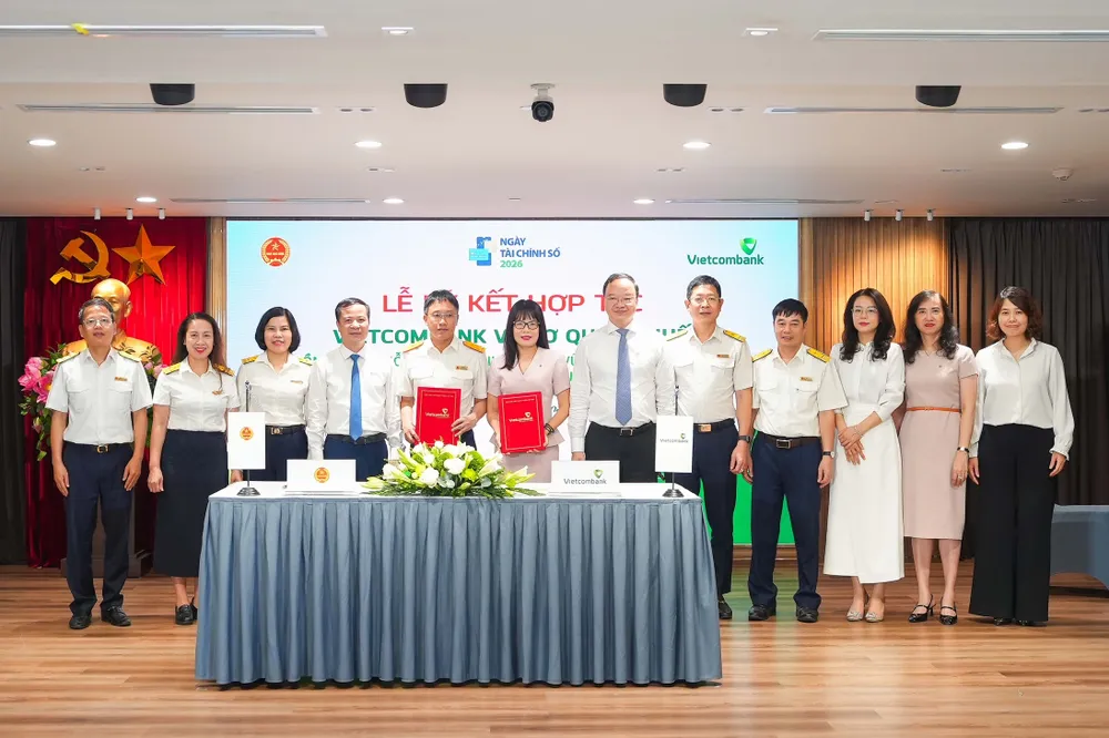 Ông Mai Sơn, Phó Cục Trưởng Cục Thuế (thứ 5, từ trái sang) và bà Đoàn Hồng Nhung, Giám đốc Khối Bán lẻ, Thành viên Ban điều hành Vietcombank (thứ 6, từ trái sang) thực hiện nghi thức ký kết và trao biên bản Thỏa thuận Hợp tác giữa Cục Thuế và Vietcombank dưới sự chứng kiến của đại diện lãnh đạo hai đơn vị