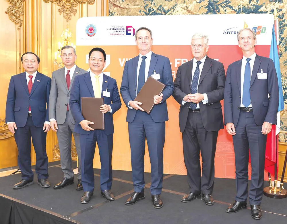 Ông Nguyễn Ngọc Nghị, Phó Tổng Giám đốc T&T Group, Chủ tịch T&T Energy Group và ông Arnaud Lenail Chouteau, Phó Chủ tịch cấp cao kiêm Tổng Giám đốc TotalEnergies Gas & Power Activities trao biên bản ghi nhớ về hợp tác phát triển Dự án điện khí LNG Long Sơn (ẢNH: ANH CHIẾN)