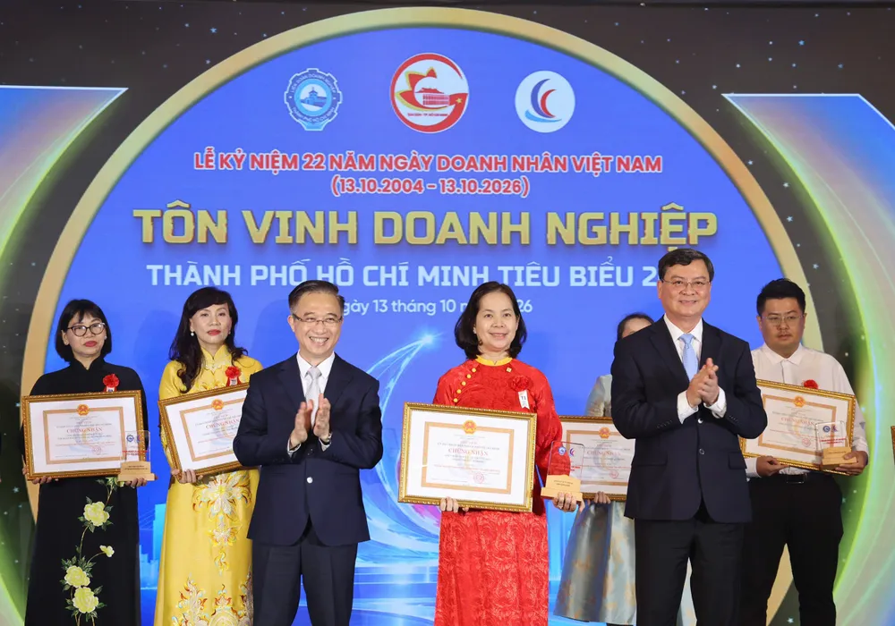 Bà Diệp Hồng Di, Phó Tổng Giám đốc Thường trực Saigon Co.op (áo dài đỏ), nhận danh hiệu Doanh nghiệp TPHCM tiêu biểu năm 2026. Ảnh: HOÀNG TRIỀU