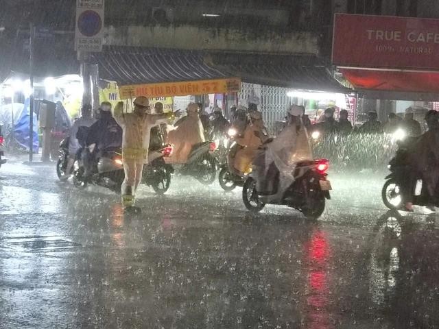 暴雨中，诺庄龙街—黎光定街交叉口交通信号灯停电，杭青交警冒雨到路口指挥交通。图：PC08