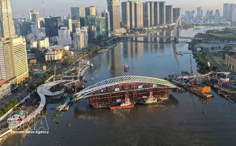 装载主跨结构的驳船就位于西贡河步行桥项目合龙位置全景图。图：越通社
