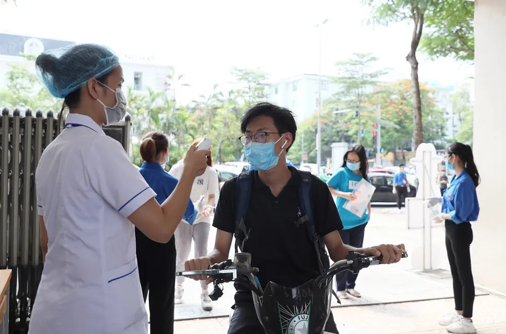Đo thân nhiệt cho thí sinh. Ảnh: QUANG PHÚC 