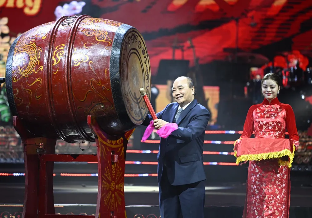 Chủ tịch nước Nguyễn Xuân Phúc đánh trống khai hội Xuân quê hương tối 14-1. Ảnh: VIẾT CHUNG