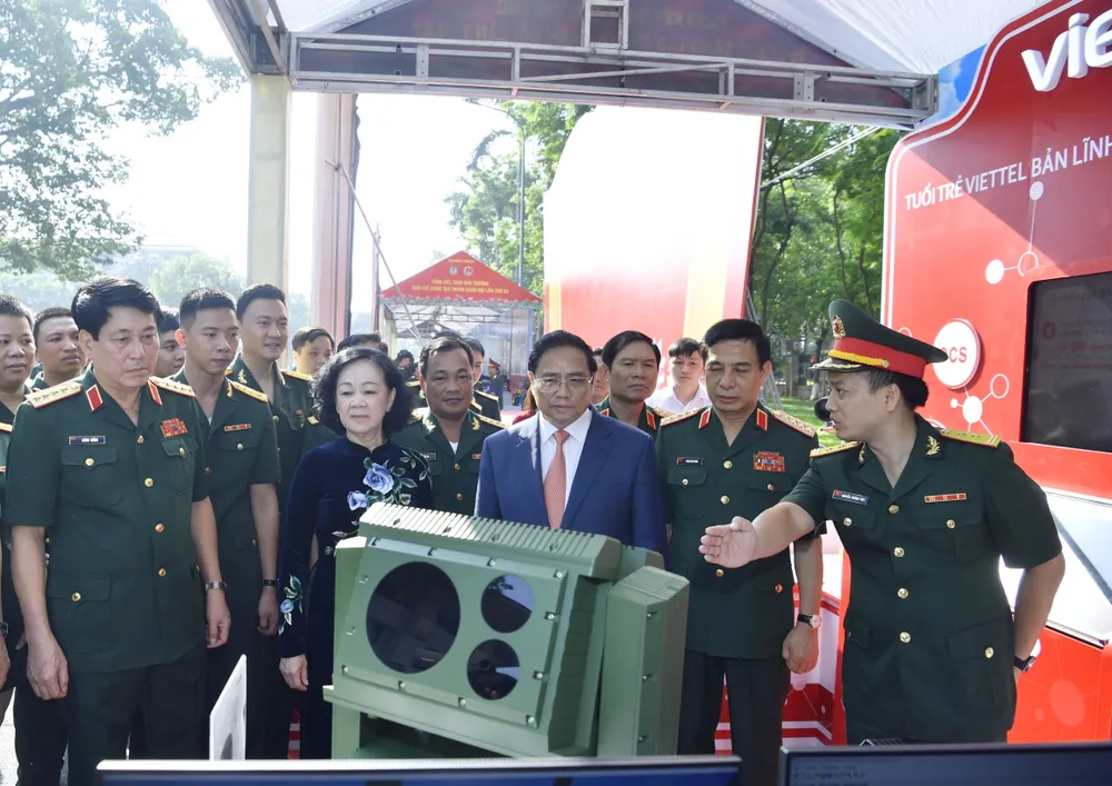 Thủ tướng Phạm Minh Chính và Thường trực Ban Bí thư, Trưởng Ban Tổ chức Trung ương Trương Thị Mai nghe giới thiệu về sản phẩm sáng tạo của tuổi trẻ trong quân đội. Ảnh: VIẾT CHUNG
