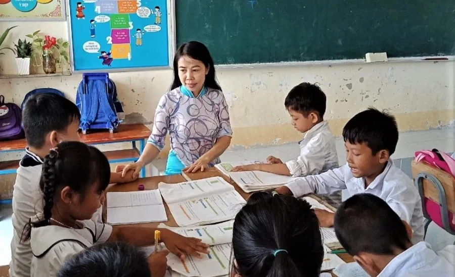 Nhà giáo Nhân dân Đỗ Thị Hồi cùng các em học sinh..png