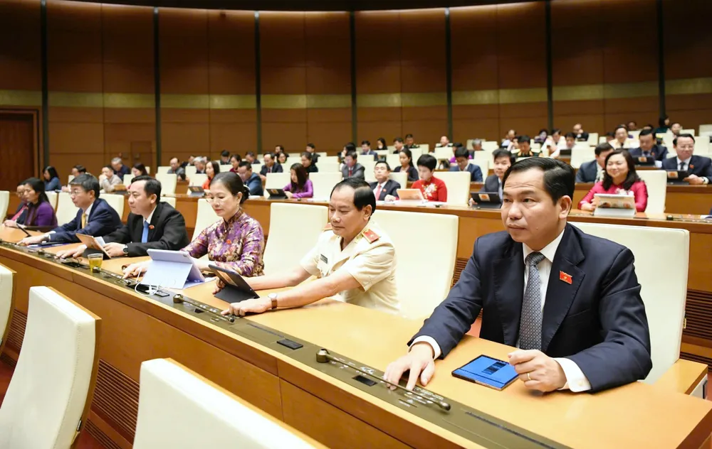 Các đại biểu bấm nút thông qua luật.jpg