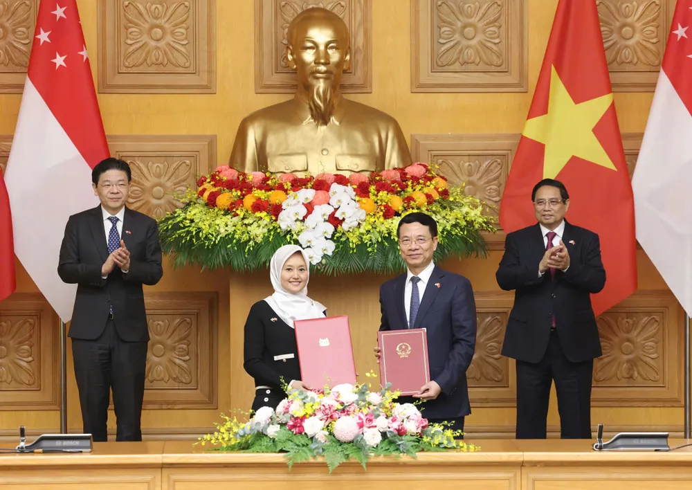 Thủ tướng Phạm Minh Chính và Thủ tướng Lawrence Wong chứng kiến lễ trao biên bản thỏa thuận giữa hai nước, sáng 26-3. Ảnh: QUANG PHÚC