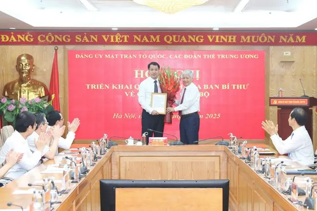Chủ tịch Ủy ban Trung ương MTTQ Việt Nam Đỗ Văn Chiến trao quyết định và tặng hoa chúc mừng đồng chí Ngô Văn Cương