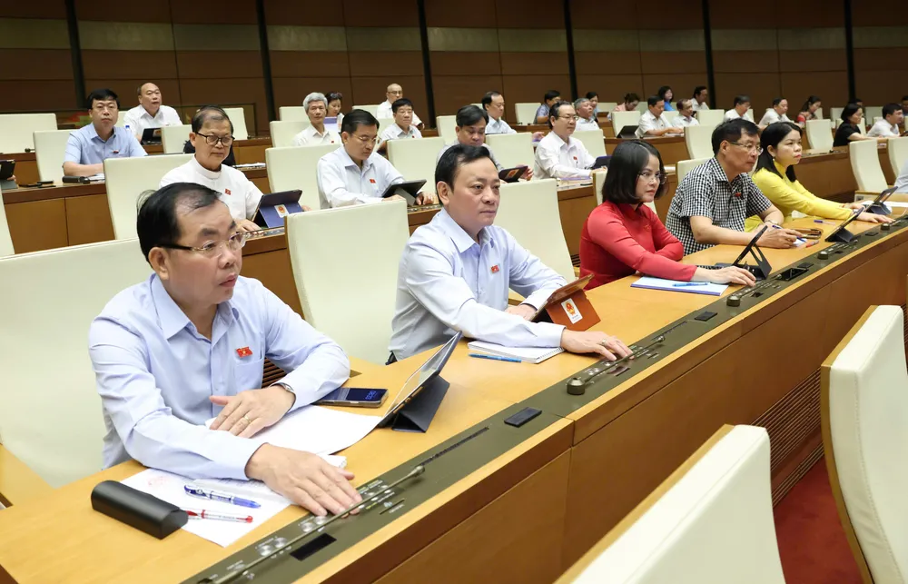 Đại biểu Quốc hội bấm nút biểu quyết thông qua luật, sáng 16-6. Ảnh: QUANG PHÚC