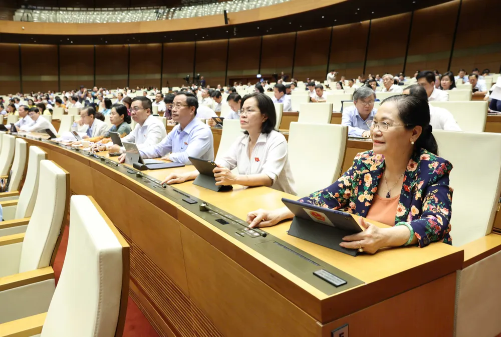 Đại biểu Quốc hội bấm nút biểu quyết thông qua luật. Ảnh: QUANG PHÚC