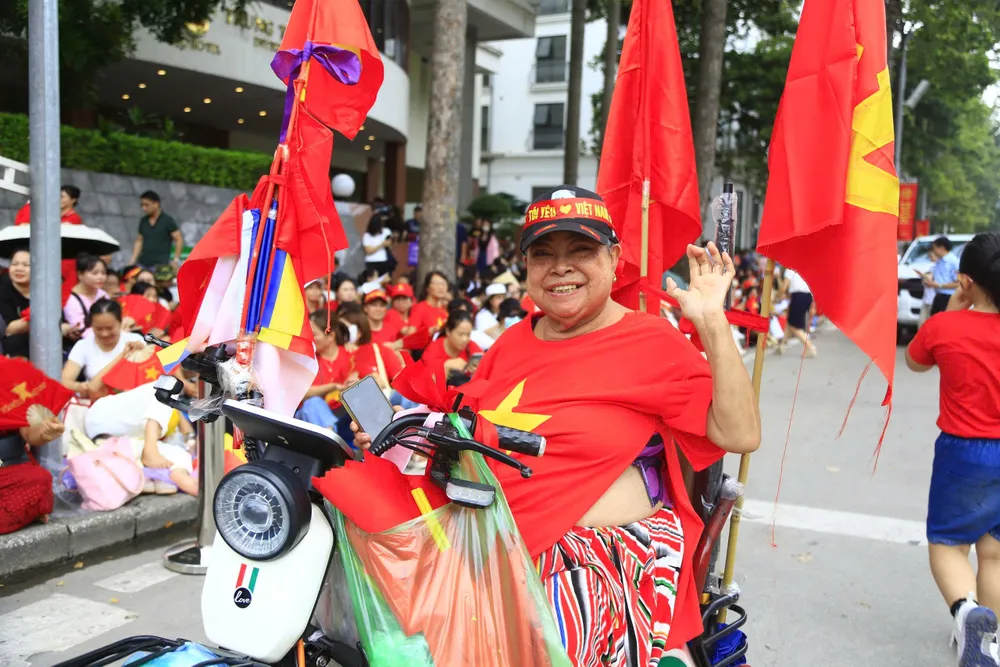 Bà cụ dù khuyết tật thể vận động nhưng vẫn hòa cùng vào dòng người xem hợp luyện. Ảnh HÀ NGUYỄN.jpg