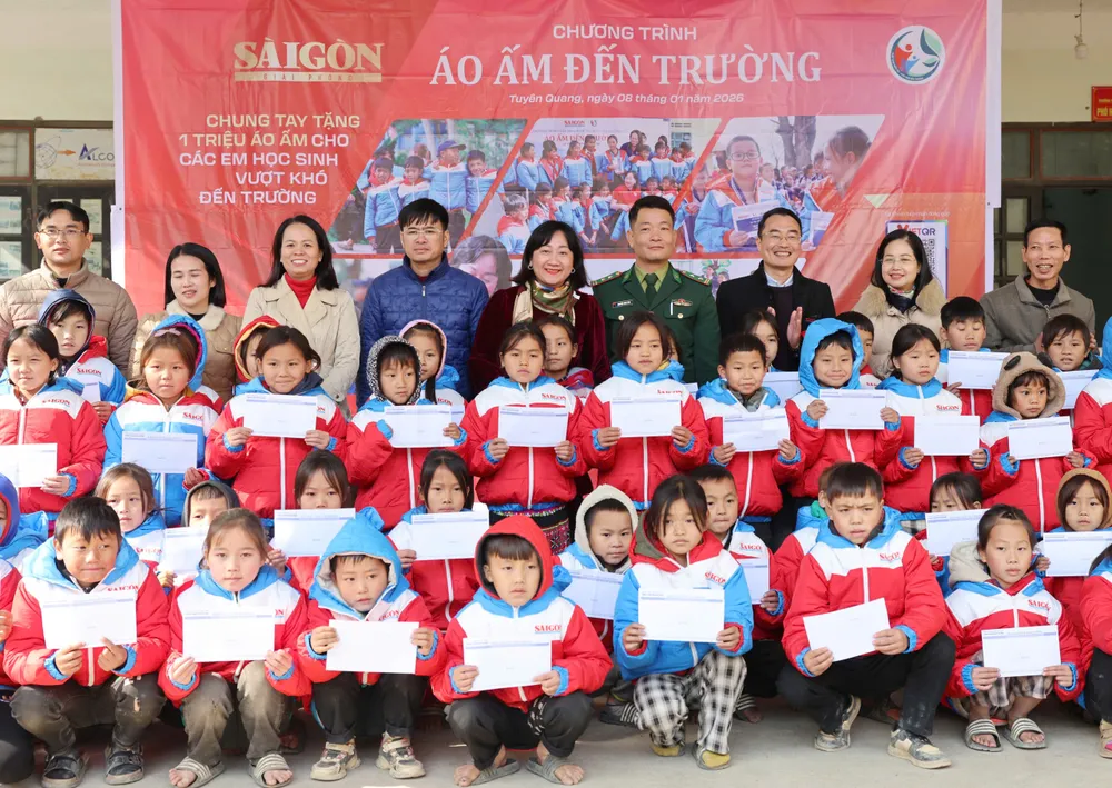 Bà Bùi Thị Hồng Sương, Phó Tổng Biên tập Báo Sài Gòn Giải Phóng và các đại biểu tặng quà các em học sinh.. Ảnh: QUANG PHÚC