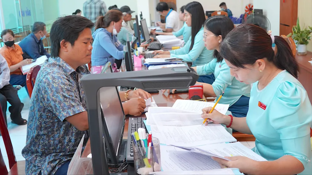Công chức, viên chức Trung tâm Phục vụ hành chính công xã Vĩnh Lộc, TPHCM hướng dẫn người dân làm thủ tục hành chính. Ảnh: QUANG HUY