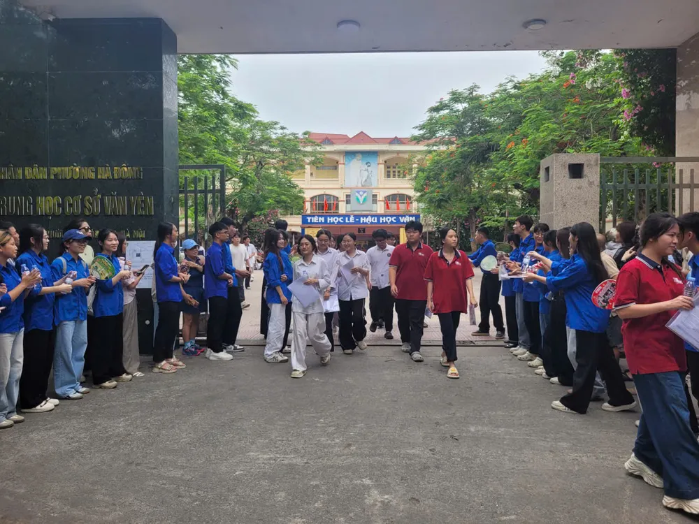 Những thí sinh đầu tiên ra khỏi phòng thi tại điểm thi Trường THCS Văn Yên, Hà Nội. Ảnh PHAN THẢO