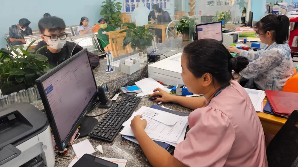 Công chức phường An Phú Đông (TPHCM) tiếp nhận, giải quyết hồ sơ thủ tục hành chính cho người dân. Ảnh: NGÔ BÌNH